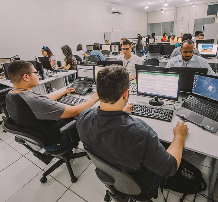 Funcionários da Engeselt trabalhando em frente ao computador
